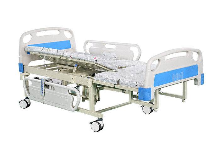Υπομονετική πλευρά που γυρίζει το ηλεκτρικό νοσοκομειακό κρεβάτι με τον ελεγκτή χεριών για τις μετακινήσεις
