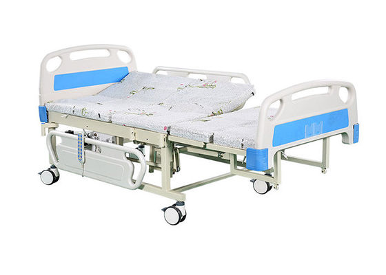 Υπομονετική πλευρά που γυρίζει το ηλεκτρικό νοσοκομειακό κρεβάτι με τον ελεγκτή χεριών για τις μετακινήσεις